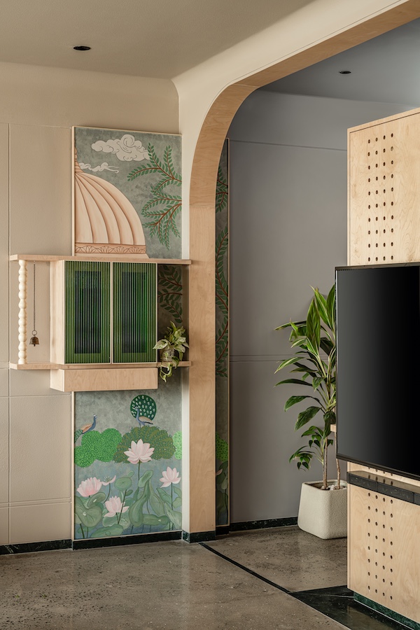  The painted dome-inspired panel, fluted glass doors and natural wood transform this pooja nook into a tranquil sanctuary. (Image credits: Noaidwin Sttudio)