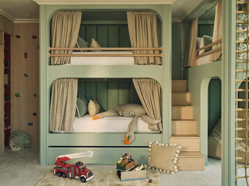 Bespoke bunk beds in Benjamin Moore ‘Raindance 1572’ with embroidered Casamance fish motifs sit atop a plush Jacaranda Arani ‘Teal Blue’ carpet, completing this playful yet sophisticated retreat. (Image Credits: Nick Rochowski)