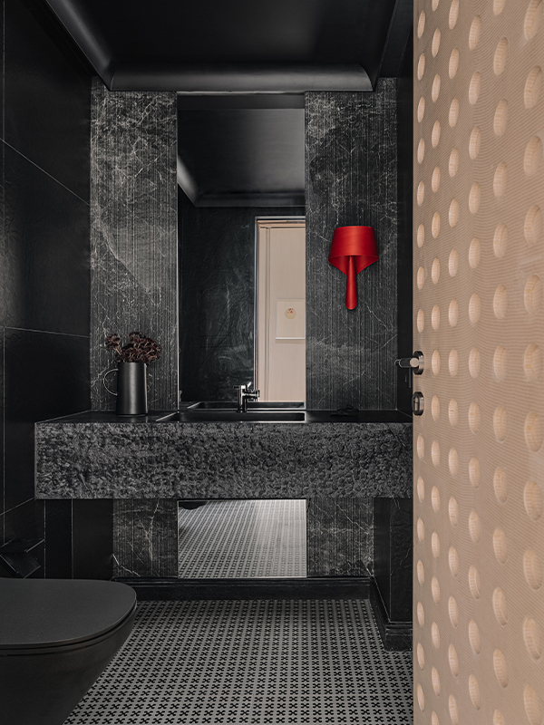 A bold, light, scarlet lighting fixture by LZF in the powder bathroom of the Kanso House, designed by Purple Backyard, becomes the focal point. (Image Credit: Ishita Sitwala) 