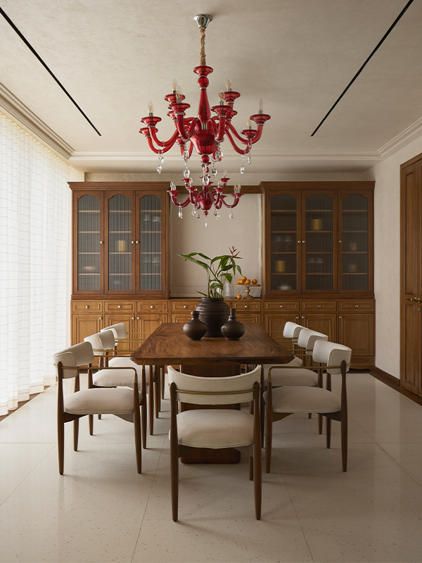In the dining room at Villa 16, designed by Insitu Design Studio, a red chandelier becomes the focal point amidst the wooden accent and furnishings from Kalakaari Haath, The Pure Concept, Azco, and Saroma. (Image Credits: Yadnyesh Joshi) 