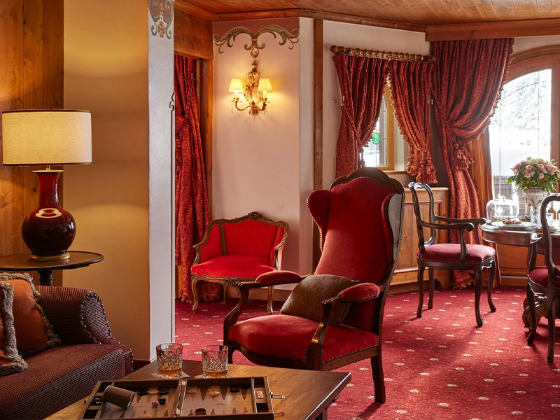 The interiors of the suite at Le Airelles comprise a pastel colour palette, wood detailing, and antique artworks. (Image Credit: Le Airelles)