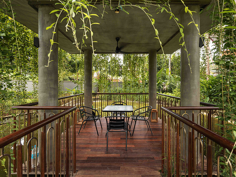 Lush greenery and a koi water body surround the intimate outdoor hosting space at the Zen Den.  (Image Credits: Turtle Arts)