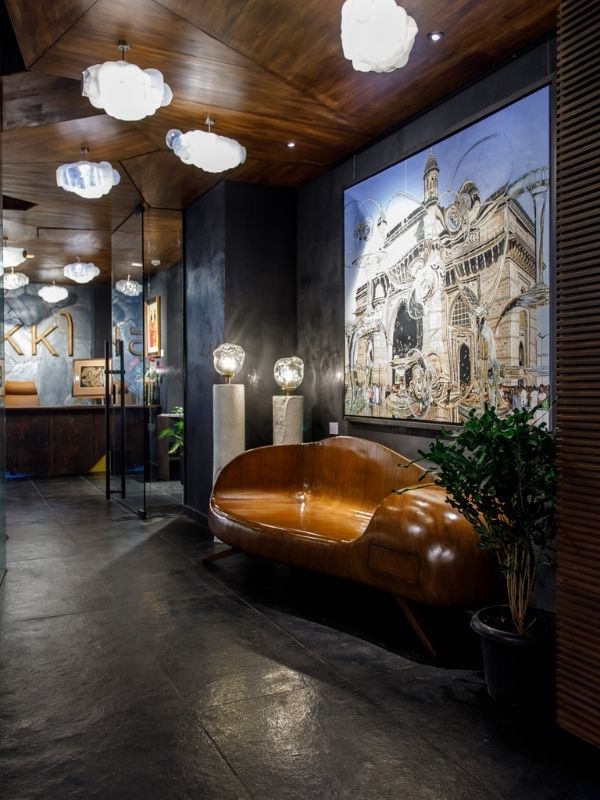 The gallery's foyer, with its black hues and wooden accents, sets the tone for the gallery. (Image Credits: Courtesy of IKKO)