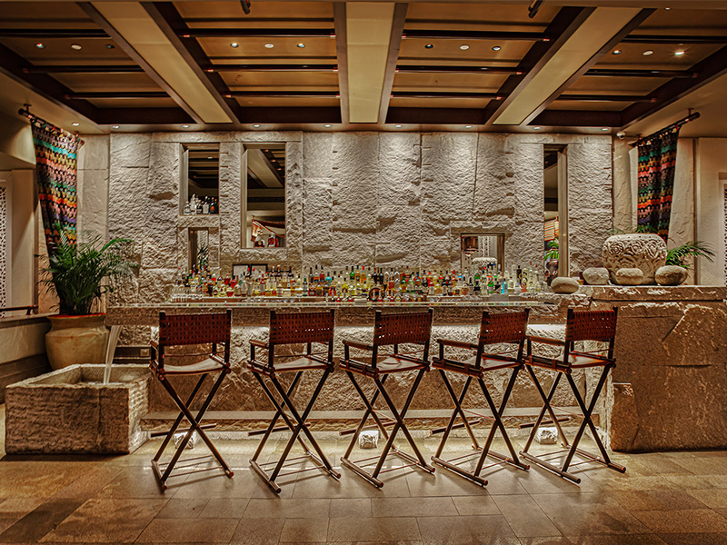 The bar’s natural textures echo the Silk Route’s rugged northern frontiers, paired with classic leather-clad campaign chairs that bring in a touch of vintage glamour. ( Image credit: Fab Studio)
