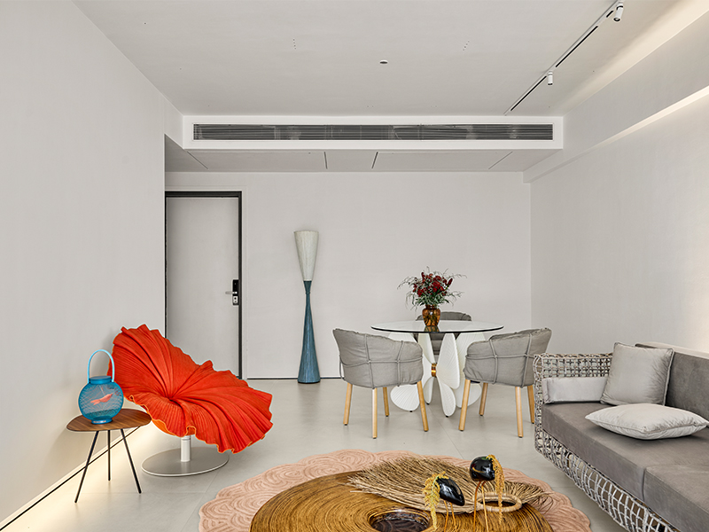 The living room features a crew of Kenneth Cobonpue furniture and totems from the crimson Bloom Chair and Fish Tail Lamps to the Cabaret Sofa, while the lighting is from Focus Lighting. (Image Credits: Isha Shah