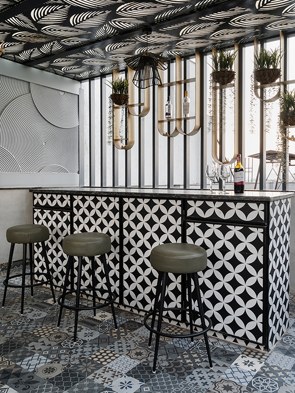 In the light-soaked living room, a beige rug from Jaipur Rugs holds a sofa and glass centre table from Tianu and refurbished vintage armchairs. (Image Credits: Phosart Studio)