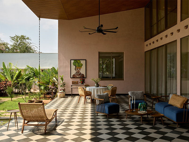 The outdoor courtyard carries a distinct look, yet seamlessly maintains a harmonious flow to and from the residence. The sofa is by D'Tale Modern, the dining set from Ventura, and the angel art from an antique store in Cochin. (Image Credits: Talib Chitalwala)