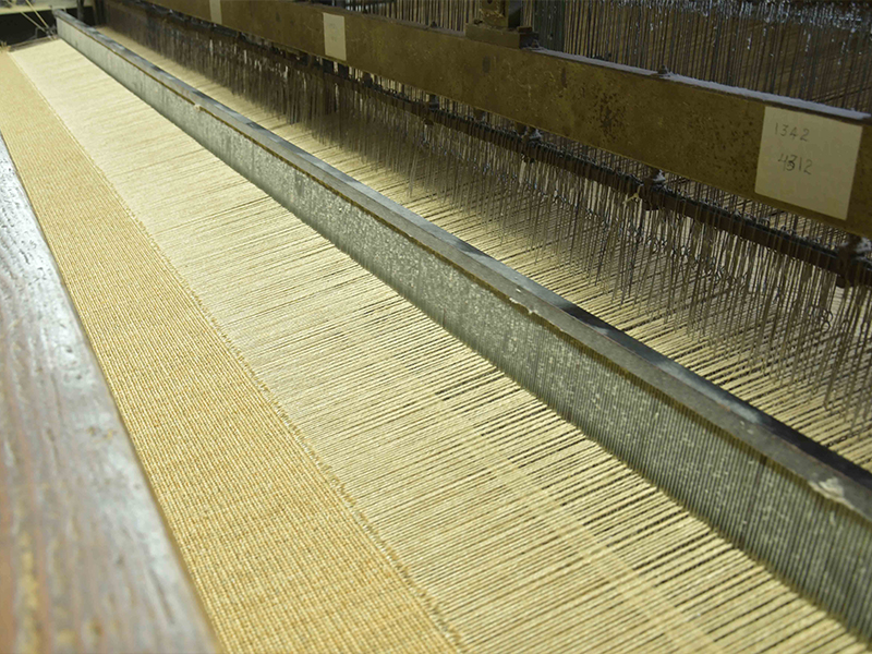 At the studio in Kerala, the bouclé weave is precisely spun on a handloom, where a needle-like shuttle delicately punctures through sisal strands, transforming raw fibre into a rich bouclé weave. (Image Credits: Courtesy of Neytt Homes)