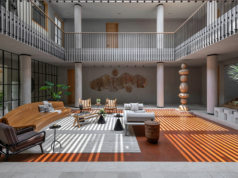 Adopting an inclusive design approach, the design team retained the original two-storey structure and built over and around it with natural stone, wood and lime wash. Here, a totem by The Wicker Story stands proud in the corner of the partially indoor courtyard (Image Credits: PHX India)
