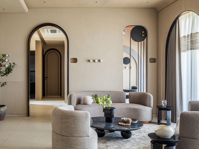 At House of Arches by Komal Sachdev, the living room features a series of arches that add a sense of symmetry to the space. It features stunning lighting fixtures by Harshita Jhamtani Designs and Hybec, along with custom wall lamps from The Lit Concept. Embellish curtains add sophistication, while decor accents from H&M Home, Altrove, and The Golden Triangle complete the look. (Image Credit: Pulkit Sehgal)
