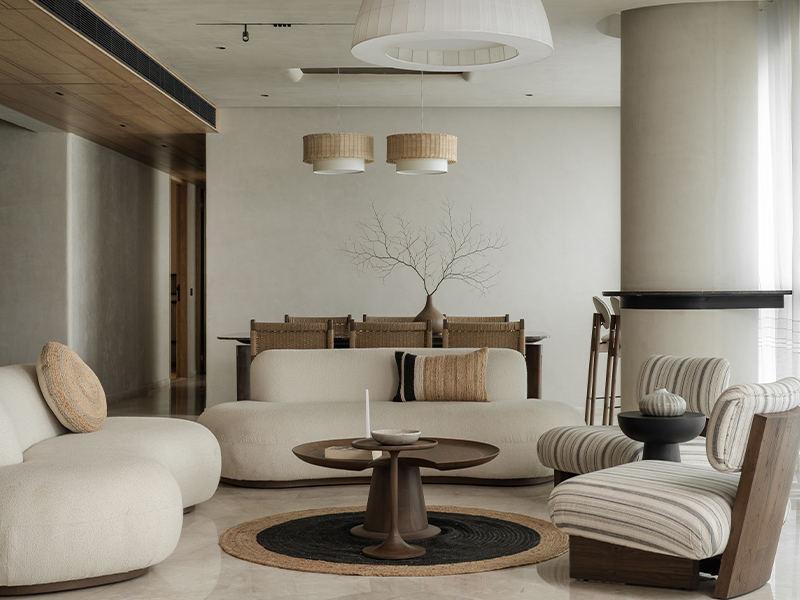 In the Oak House, designed by Studio Poche, the living room is drenched in natural light streaming in through the window, while the sheer white curtains add a sense of serenity to the publicly accessible area. (Image Credits: Harsheen Mengar)