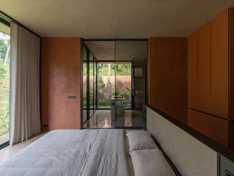 The primary bedroom unfolds into a spacious walk-in closet, designed for both elegance and ease. Ambient lighting by Plus Tech and Interstellar adds a gentle glow, while layered textiles—from Asian Paints’ drapes to Live Linen’s natural fabrics—bring a soft, tactile richness to the space. (Image credit: Syam Sreesylam)