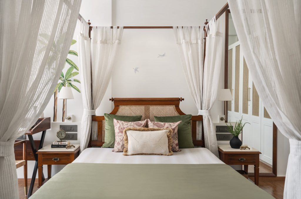 The master suite comes alive with earthy sensibilities and a hint of old-world charm, with a four-poster bed as its focal point. The leafy and avian decals from Kalakaari Haath introduce a layer of subtle drama. (Image Credits: Biju Gopal) 
