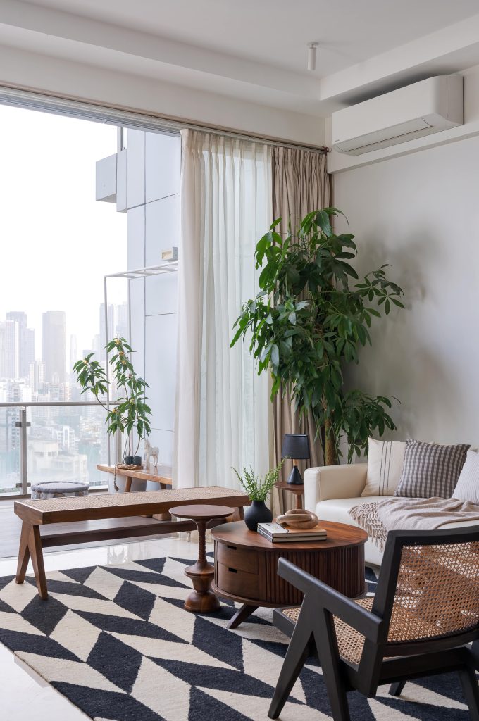 Cohesion In Every Corner Compact but intuitive, the dining area revolves around a circular black-polished table, surrounded by rattan and teak chairs. The sacred space, too, follows the same temperate language — a slim ledge with a fluted glass backdrop replaces the typical mandir, culminating in a corner that melds seamlessly into the room. 