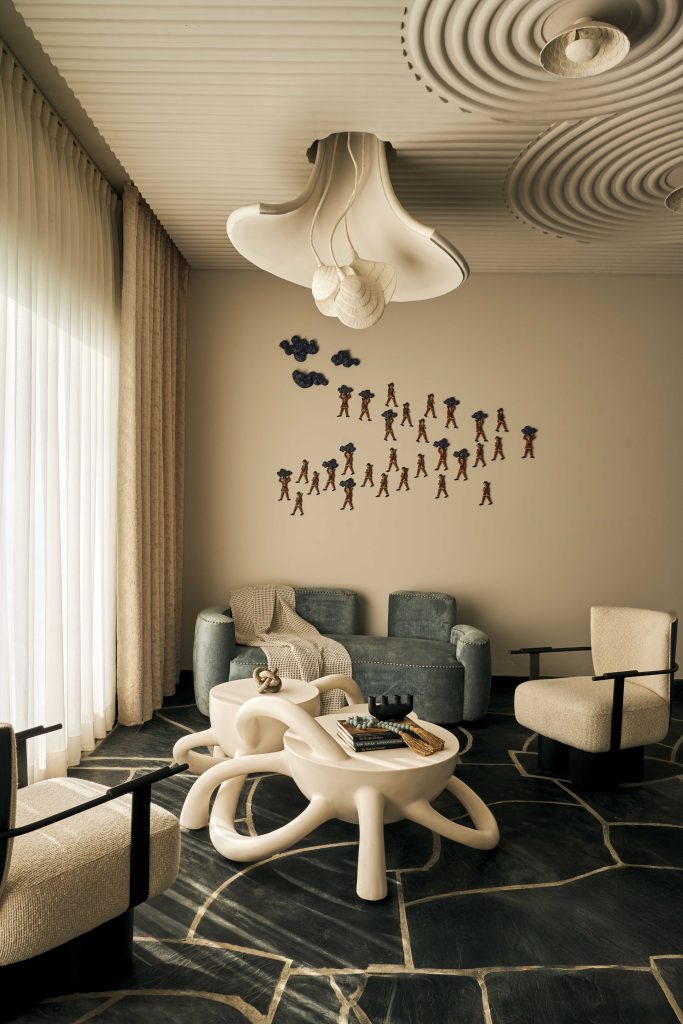 This refined bar corner features Shailesh Rajput Studio’s striking suspended lights, Ashiesh Shah’s sculptural Swayam Table, wall art from Art Centrix Space and elegant fabric-rich seating by Season Furnishings. (Image Credits: The Matter Studio)