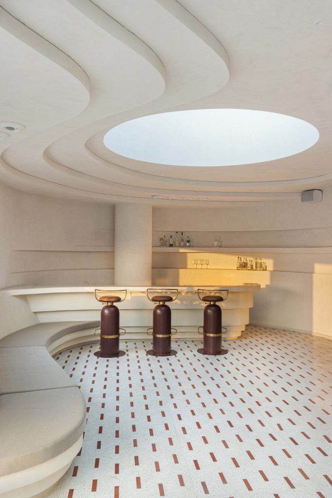 In the semi-covered lounge, fluid contours trickle into the walls, Roschcrete terrazzo flooring, the Nama Home bar stools and MuunHome coffee tables. (Image Credits: Purnesh Dev Nikhanj)