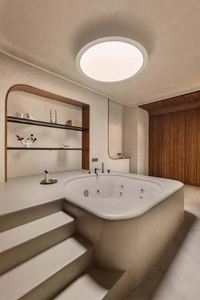 The adjoining spa retreat explores smooth curves with Colortale microtopping flooring, MCM clay cladding and mosaic accents by Piccolo Mosaics. (Image Credits: Purnesh Dev Nikhanj)