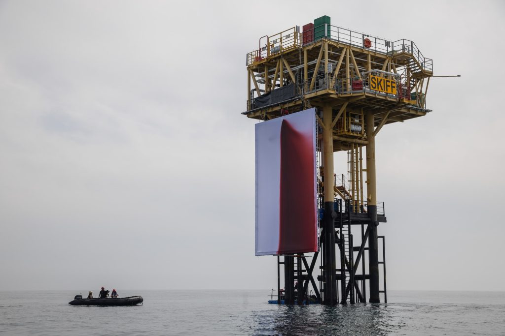 Seven Greenpeace climbers scaled the gas rig to hoist the artwork. (Image Credits: Greenpeace)
