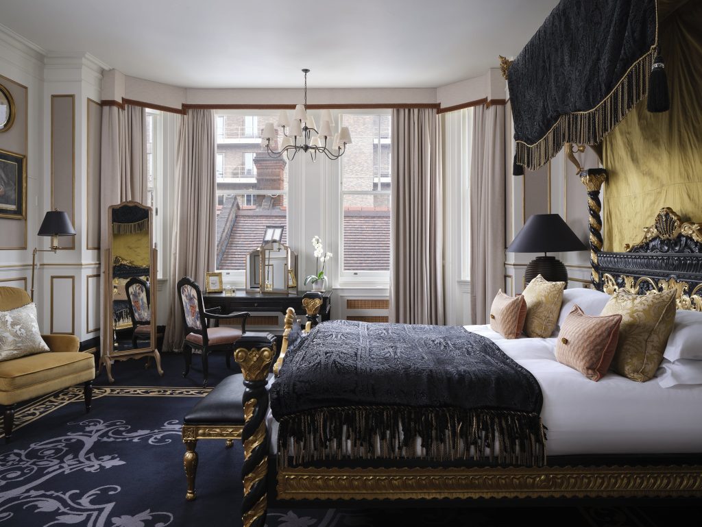 The Sloane Suite, located on the ground floor, is elegantly appointed with antique furnishings and features a spacious living and dining area finished in a refined palette of gold, cream, and black. (Image Credit: 11 Cadogan Gardens) 
