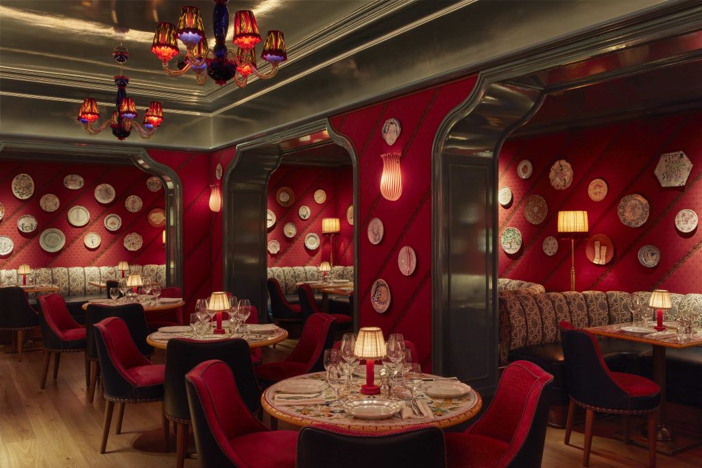 Seductive Murano glass lighting, red silk-lined walls, and plush booth seating conjure an atmosphere of discreet intimacy, where dolce vita elegance meets unapologetic disco glam. (Image Credit Broadwick Soho) 
