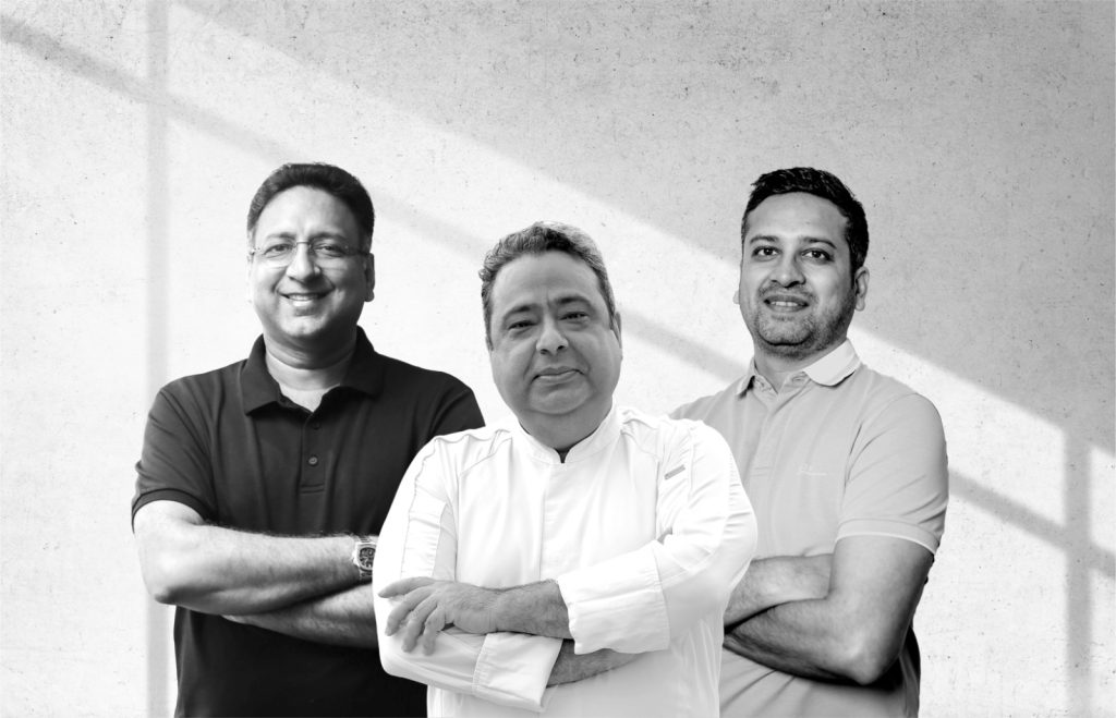 Chef Manish Mehrotra, backed by Amit Khanna (left) and Binny Bansal (right), unveils ‘Manish Mehrotra Culinary Arts’ (MMCA). (Image Credits: Manish Mehrotra Culinary Arts) 