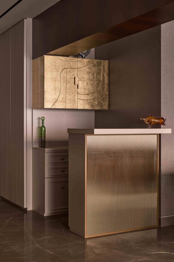 A fluted bar cabinet with golden mirror from Khozem Glass custom designed by Jasani becomes both a functional anchor and focal point tucked into a corner of the open-plan living area. (Image Credits: Yadnyesh Joshi) 