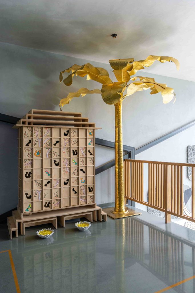  A birch ply mandir with hand-painted motifs standing beside a sculptural golden tree is a contemporary interpretation of tradition, tactfully balancing modern restraint with expressive geometry. (Image Credits: Ricken Desai) 