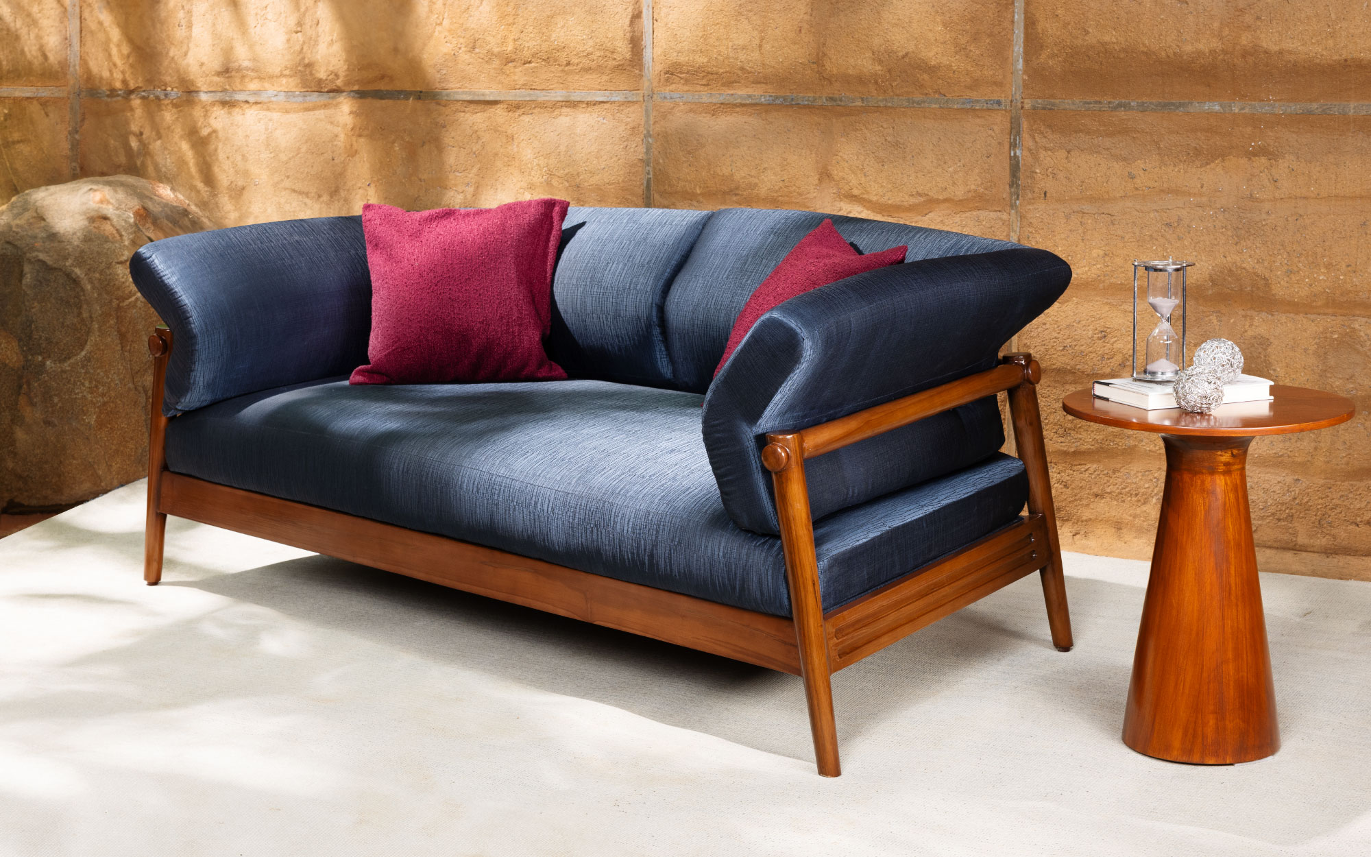 The Athena sofa pays homage to South India’s ancestral homes with its sleek wooden base and sumptuous silk upholstery. (Image Credits: Lagom)