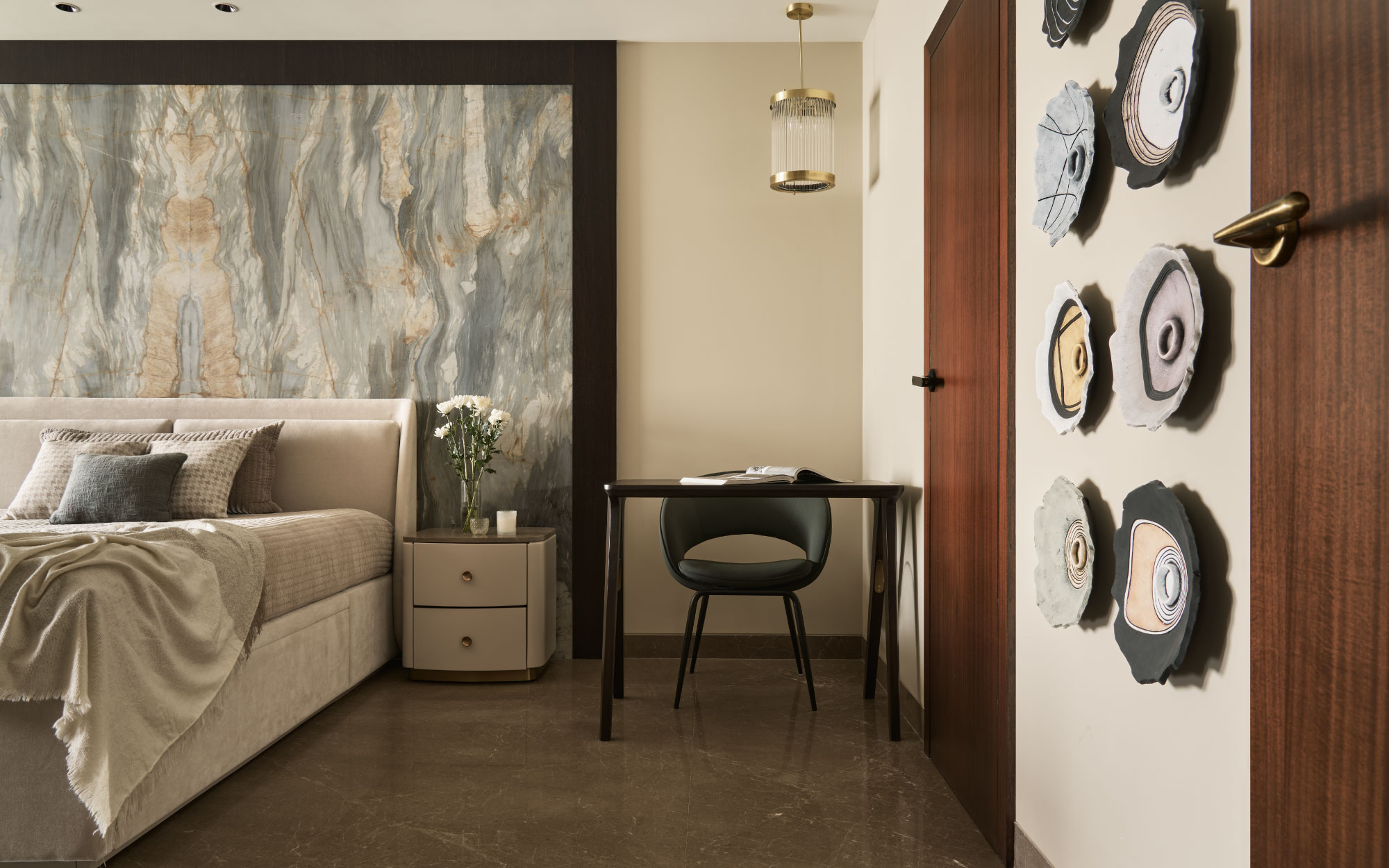 The daughter’s bedroom with a customised fabric-clad bed against an accent wall with marble sourced from Stone Source Select is a quiet symphony of texture and light designed to soothe. A customised desk is paired with a Kerf Living chair.  (Image Credits: Yadnyesh Joshi)