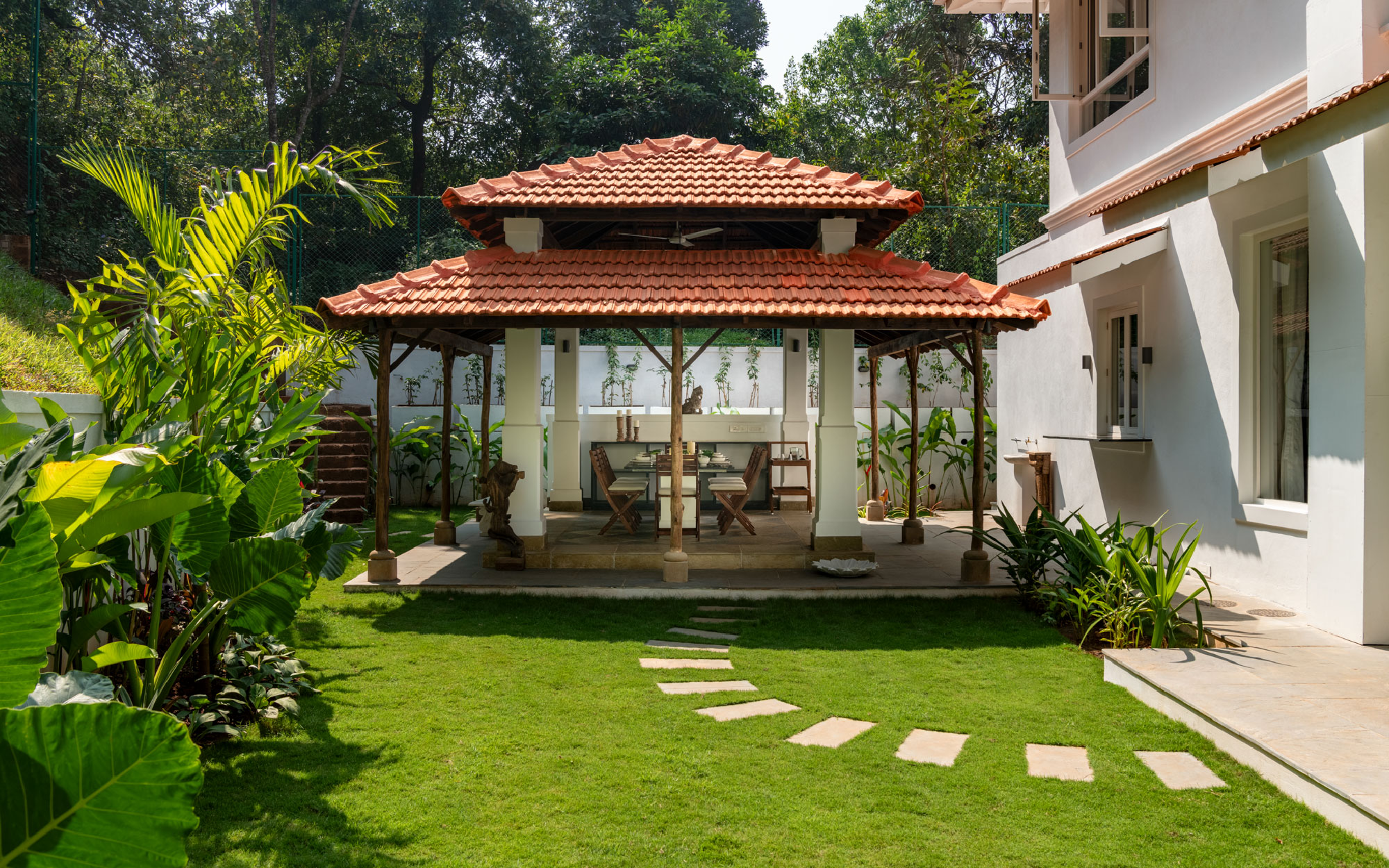 This gazebo exemplifies sustainable design, featuring natural stone flooring, clay tile roofing, and thoughtfully planned landscaping that preserves the existing vegetation. (Image Credits: Graf Media)