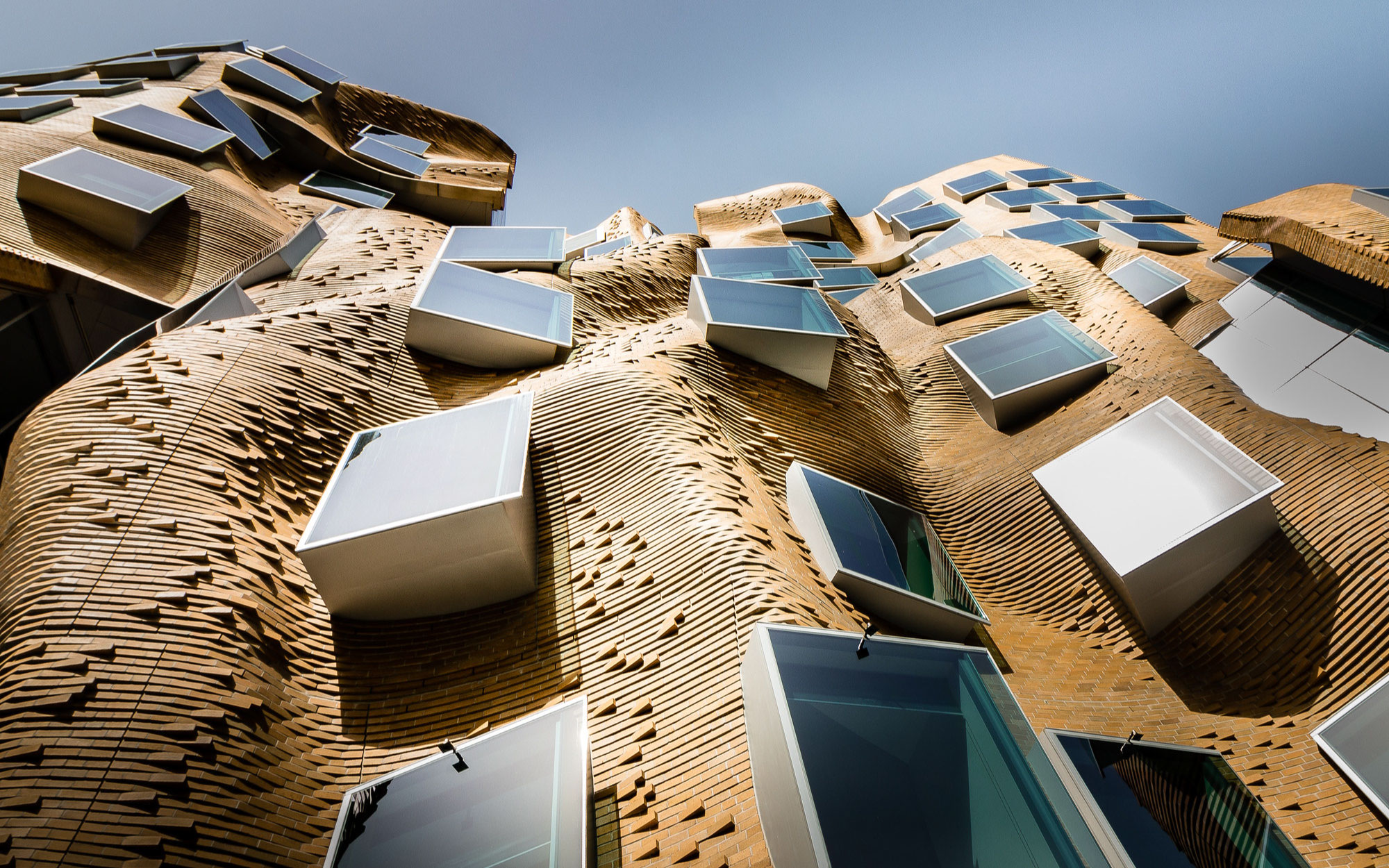 The Dr. Chau Chak Wing Building, part of the University of Technology in Sydney, clad with undulated bricks, is Frank Gehry‘s first building in Australia. (Image Credits: Martin Snicer)
