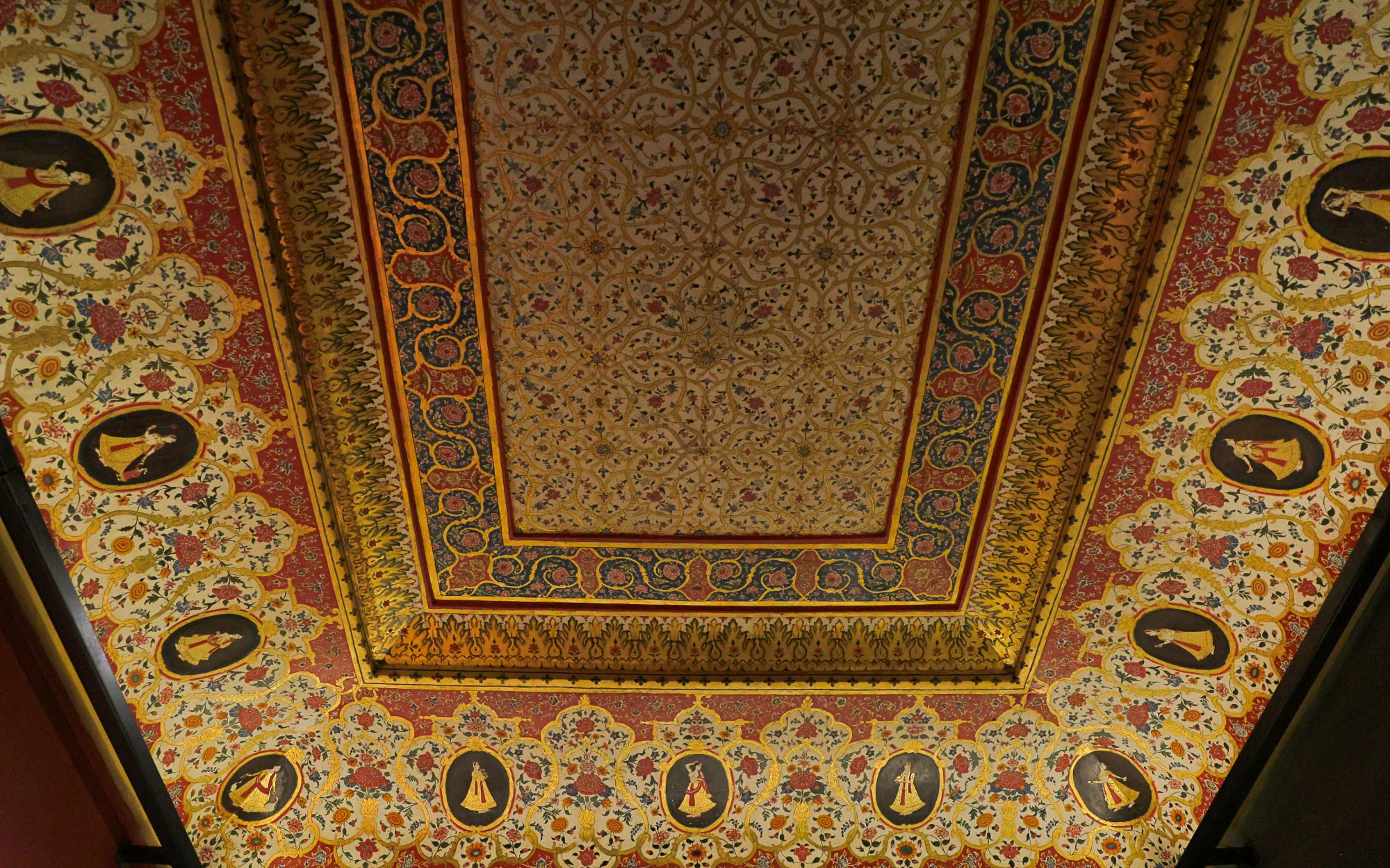 Finished by gesso coats and steeped in the Usta tradition, it presides over the arms beneath, intruding softly to narrate histories beyond the objects it shelters. (Image Credits: City Palace Museum)