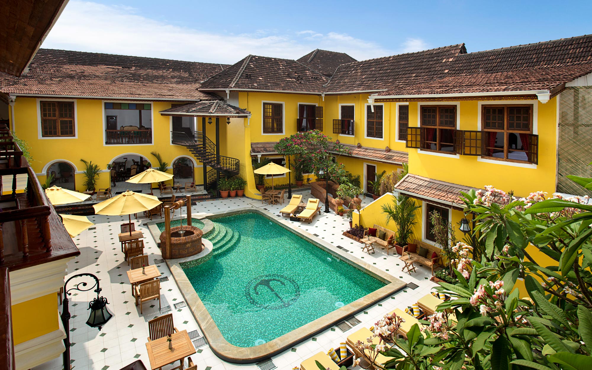 A sunlit moment at Forte Kochi, where the yellow exterior frames its colonial-era architecture. (Image Credits: Forte Kochi)