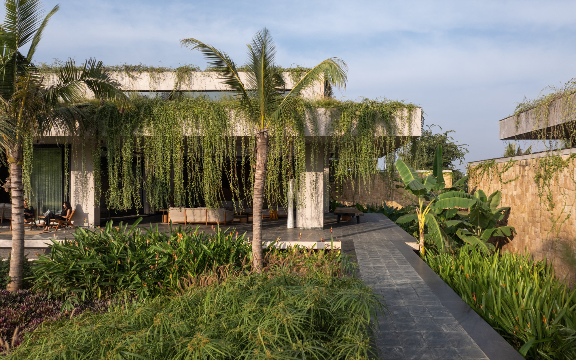 A floating walkway is sculpted from locally sourced Markapur stone, bordered in Kota. Curated shrubs and date palms along the Khamman brown sandstone wall are arranged artfully by Kiasma Studio. (Image Credits: Shamanth Patil)

