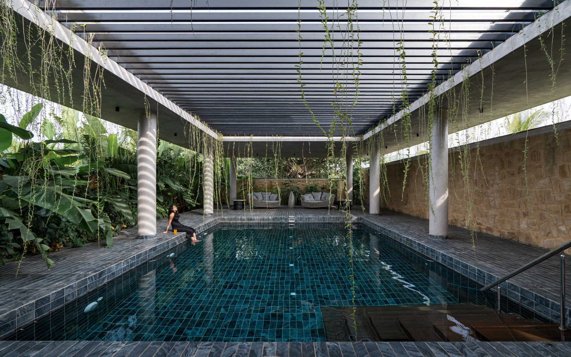 The pool forms a calming haven, strategically exclusive, bordered in cooling Markapur slate. The metal slatted sky-view central ceiling lets in dappled sunlight.  (Image Credits: Shamanth Patil)
