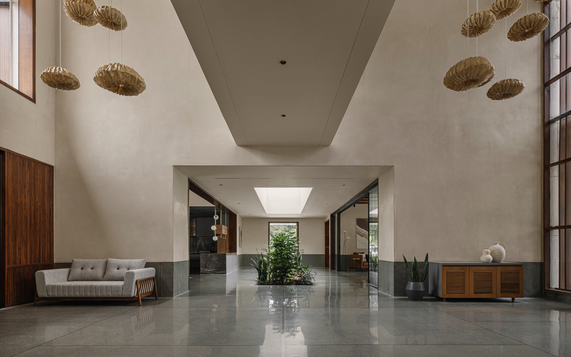 Oorja’s banana fibre paper pendants hanging in the vestibule leading to the central courtyard lend a folded, organic softness to the otherwise linear space. (Image Credits: Ishita Sitwala)